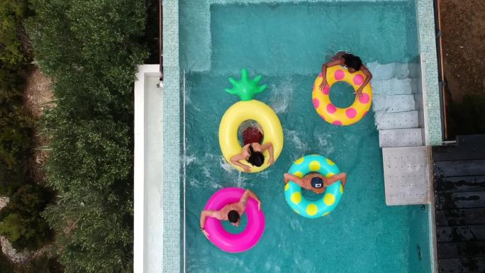 一群朋友在游泳池里玩充气环