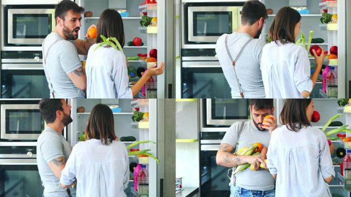一对快乐的年轻夫妇从冰箱里拿蔬菜做早餐