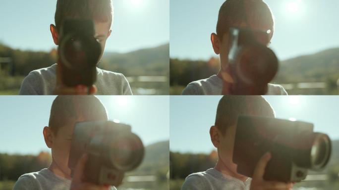 一个小男孩用相机小孩儿童摄影拍摄童年童真