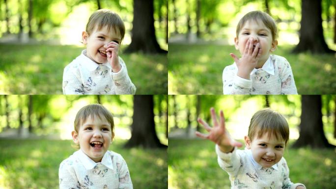 女孩看着照相机户外森林阳光飞吻可爱小孩