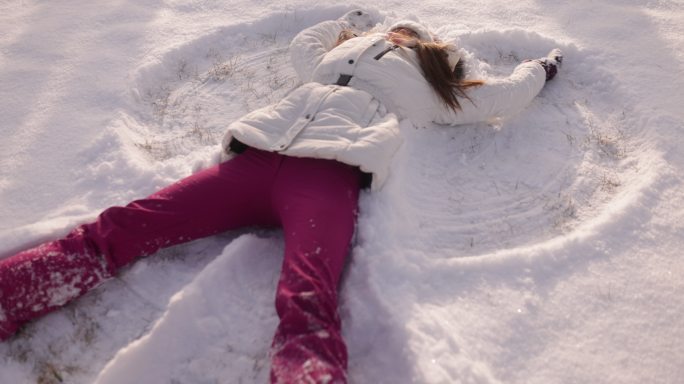 少女喜欢在新鲜的雪地里做雪天使