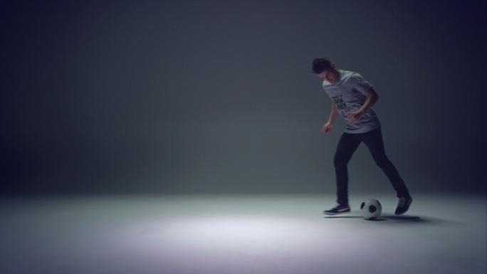 年轻的男子踢足球一个人爱好颠球进入画面室