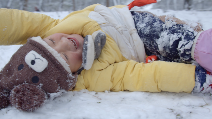 可爱小孩在雪地里开心打滚