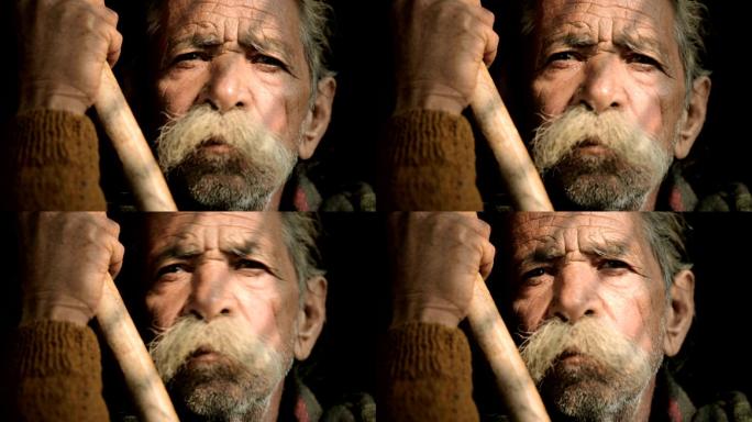 大胡子老人手持竹竿的肖像。