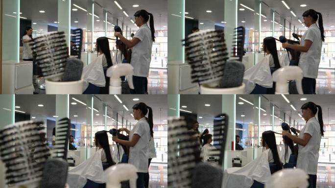 理发师用吹风机和刷子吹干顾客的头发
