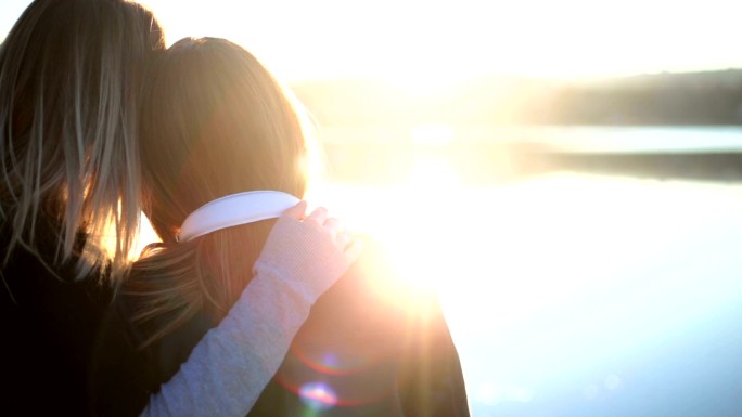 湖面上夕阳下的两个快乐女人