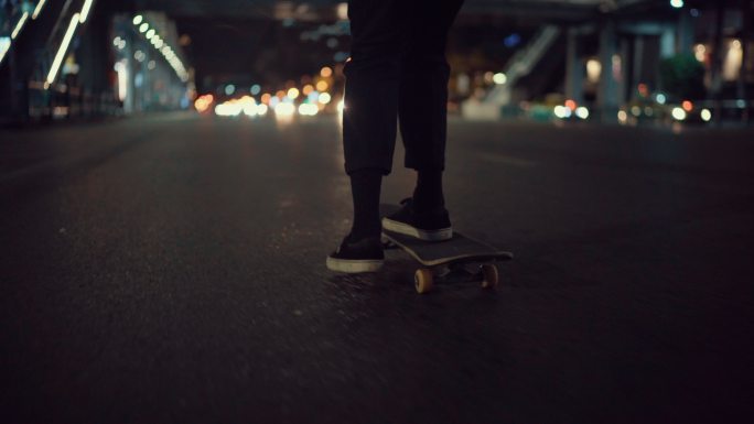 年轻人晚上在城市街道上玩滑板
