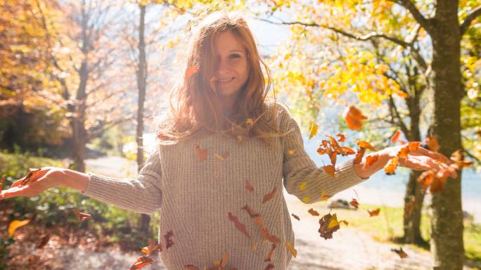 在大自然中享受阳光明媚的秋日的年轻女子