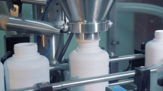工业机器将药品放入塑料罐中