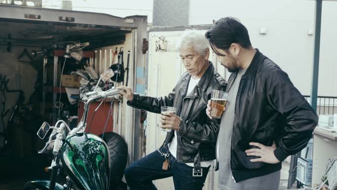 父子俩喝啤酒并讨论摩托车