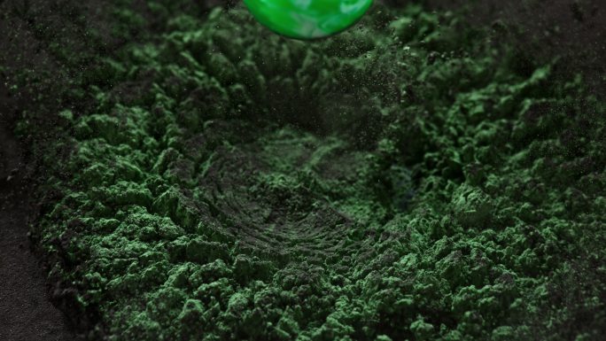 一个绿色的球掉进一堆黑绿色的灰尘里