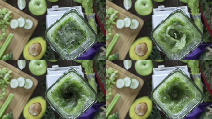 慢动作拍摄的搅拌机混合蔬菜和水果排毒冰沙。