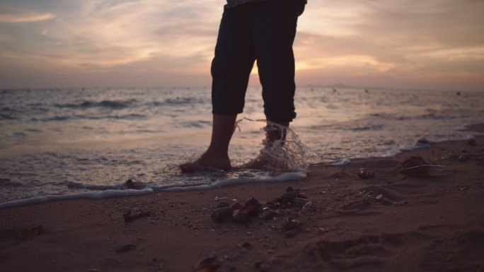 在海边散步的男人赤脚光脚黄昏晚霞傍晚漫步