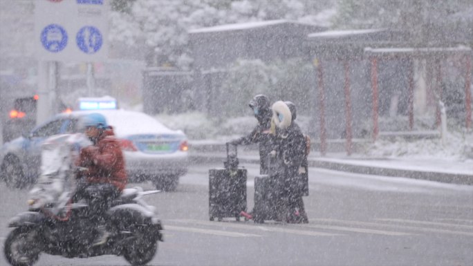 下雪天情侣拖着行李箱回家过年