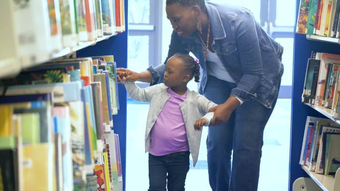 小女孩和妈妈在图书馆寻找一本书。