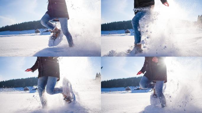 年轻女子在粉状雪地上奔跑