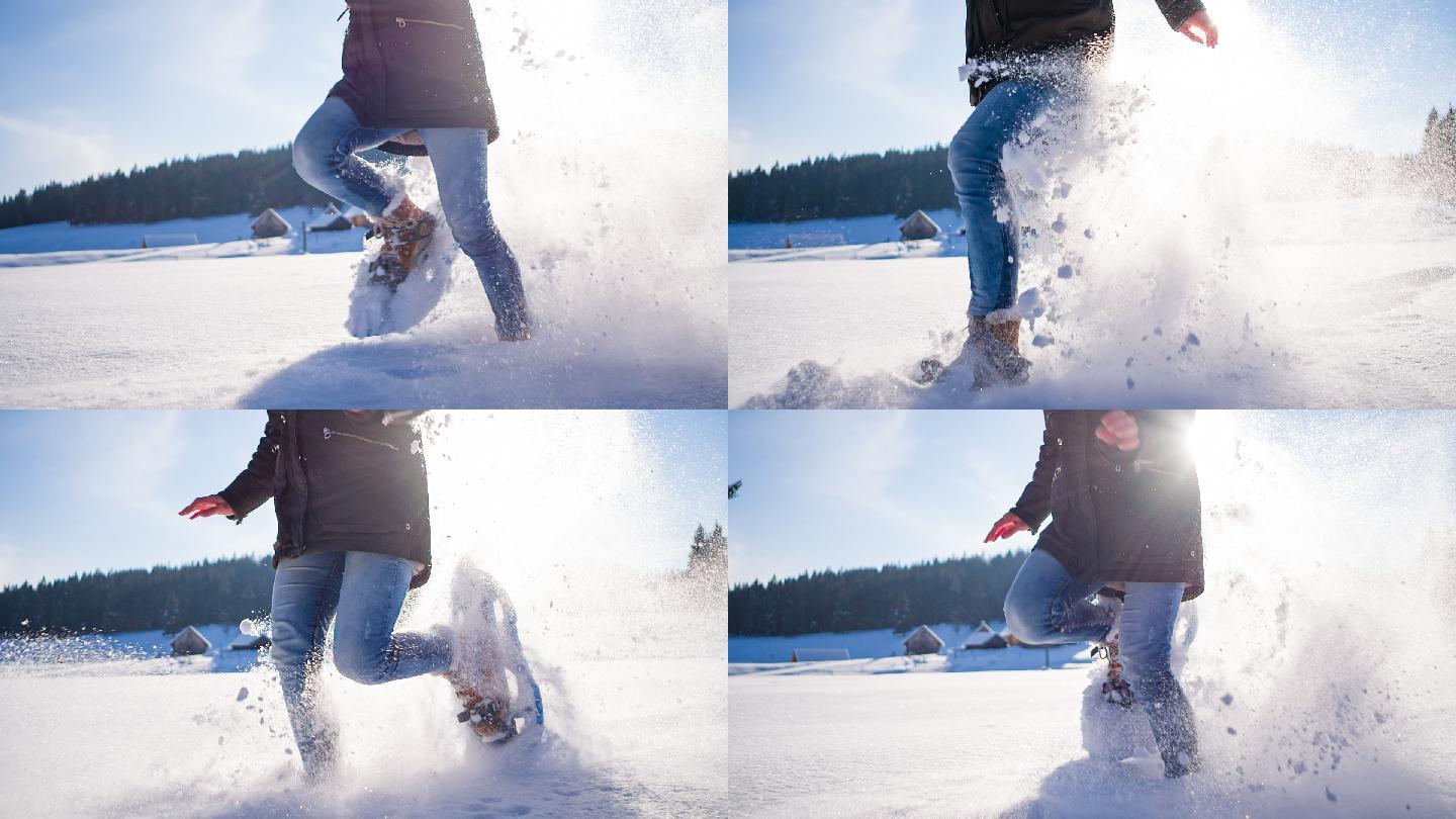 年轻女子在粉状雪地上奔跑