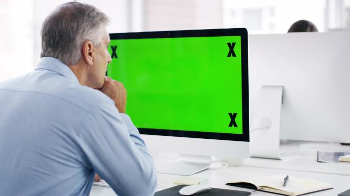 商人在办公室使用绿色屏幕电脑