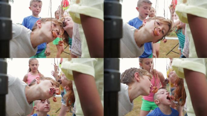 儿童玩派对吃甜甜圈游戏的特写镜头
