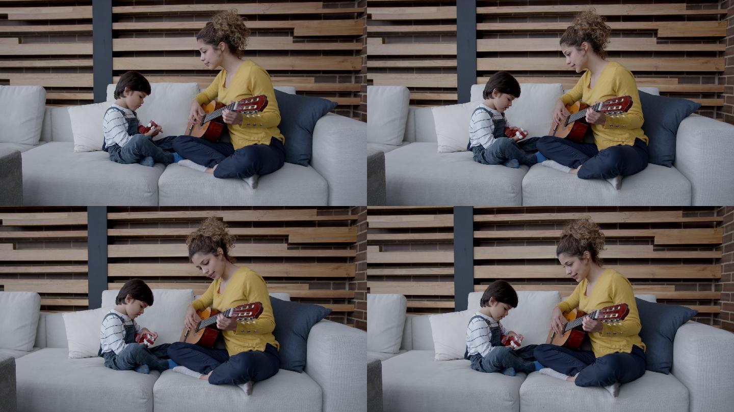 快乐的男孩在家和妈妈学吉他
