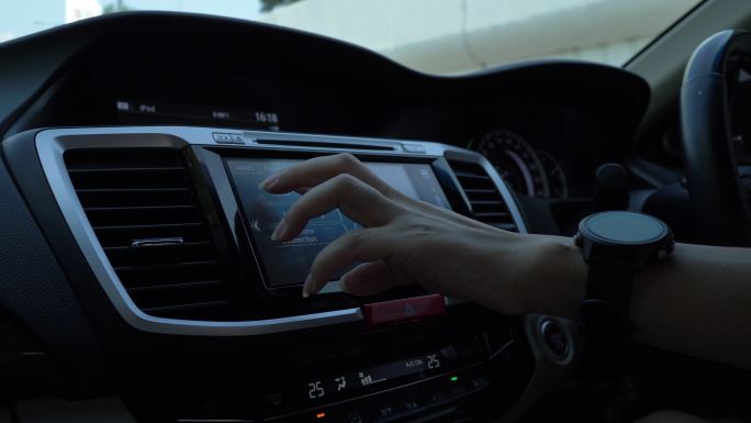 女士在车内使用触摸屏仪表板控制