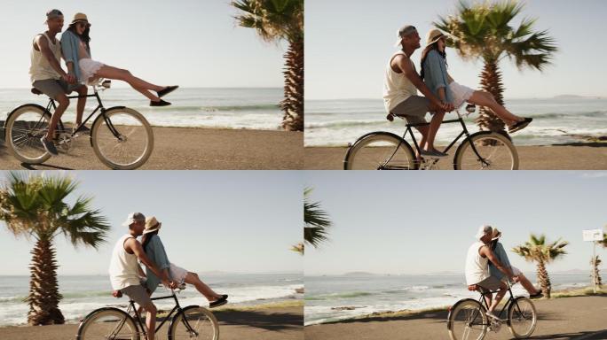 一对年轻夫妇在海滩边骑自行车
