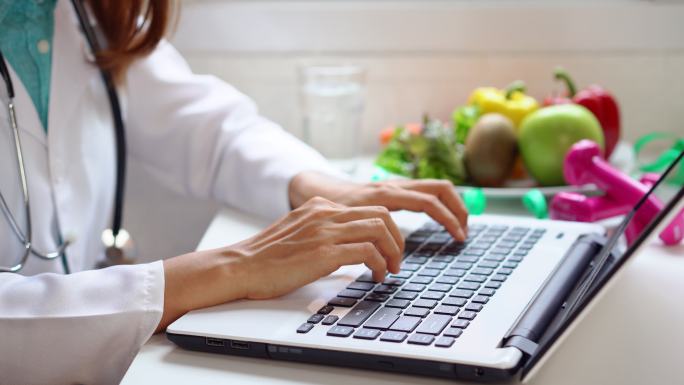 营养师使用笔记本电脑为患者提供建议