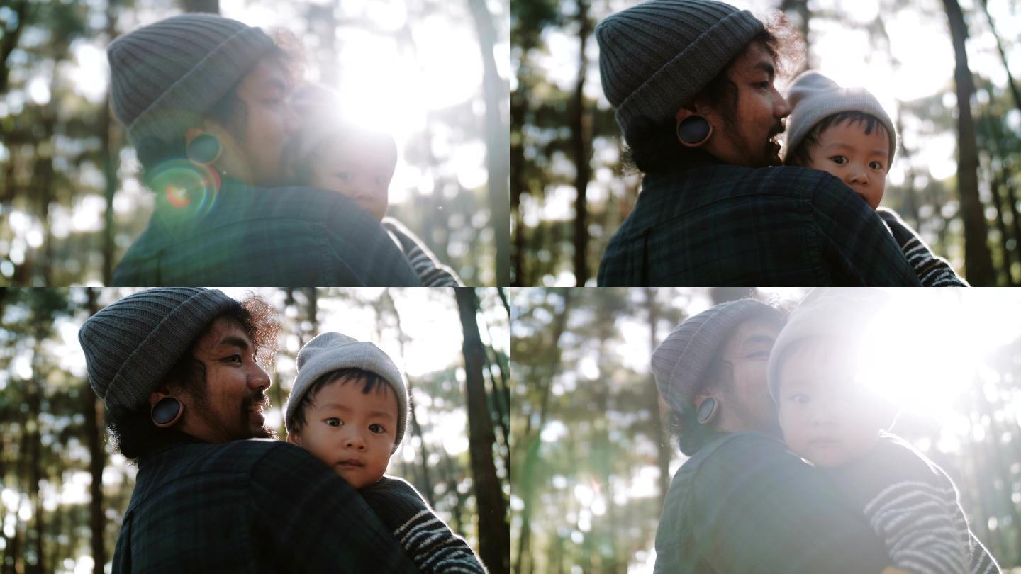 父亲冬天在树林里抱着他的孩子。
