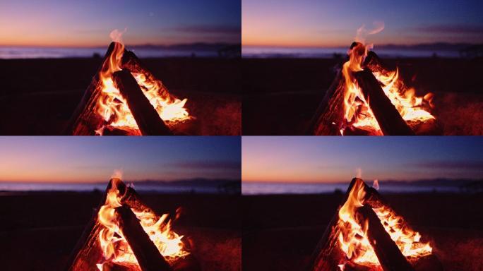 日落时海滩上燃烧着的火