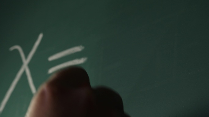 拿粉笔在黑板上写方程式的人手
