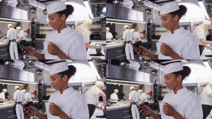 女厨师穿着厨师白衣服，在餐厅厨房里打电话