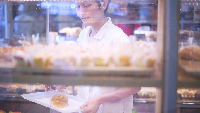 女人在超市的面包店挑选面包