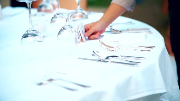 餐厅工作人员为晚宴或婚宴安排户外餐桌。