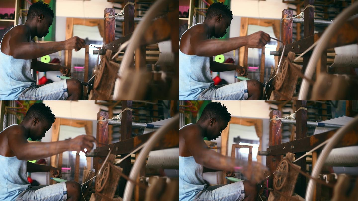 一名年轻男子在纺织生产车间内使用纺车