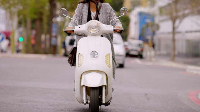一名妇女骑着电动车穿越城市的4k视频片段