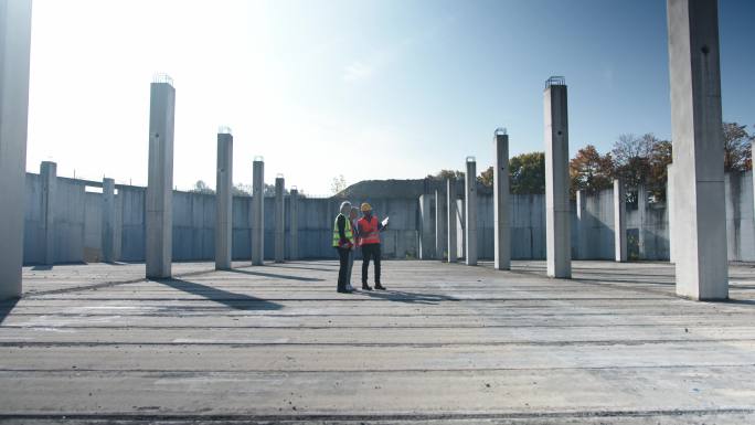 建筑工人在空旷的建筑工地周围走动