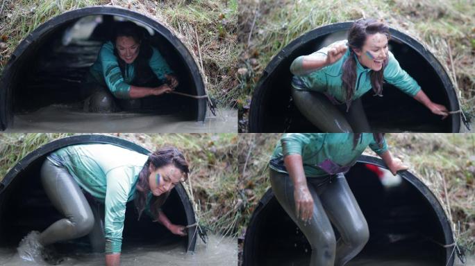 一个女人正穿过一条湿泥泞的隧道