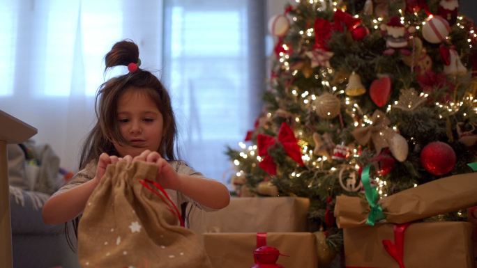 可爱的孩子在树下打开礼物