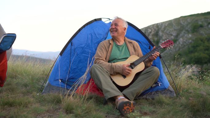 宿营时坐在帐篷前弹吉他的老人