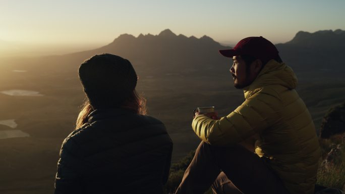 两个人在山顶时坐下来休息
