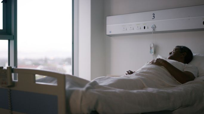 一名老年患者躺在医院病房的床上