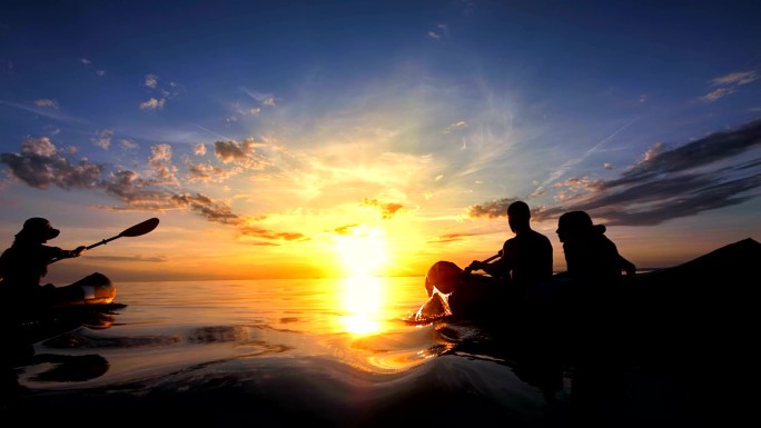 远景：日落中的家庭海上皮划艇