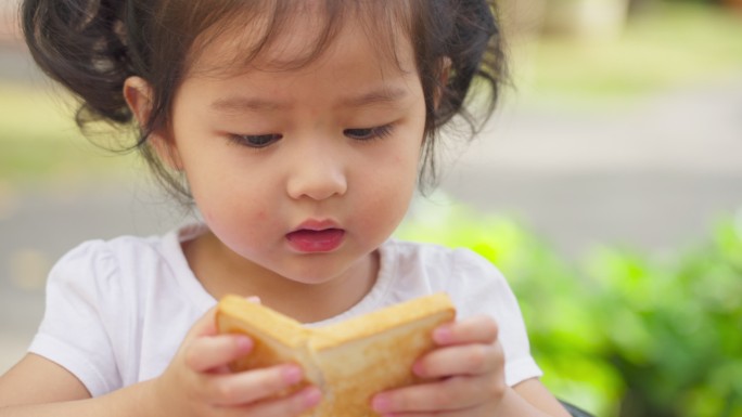 小女孩在吃黄油面包
