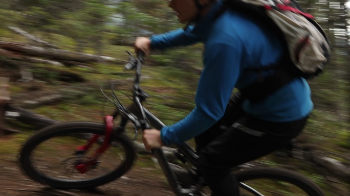 山地摩托车手以极快的速度穿越森林小径
