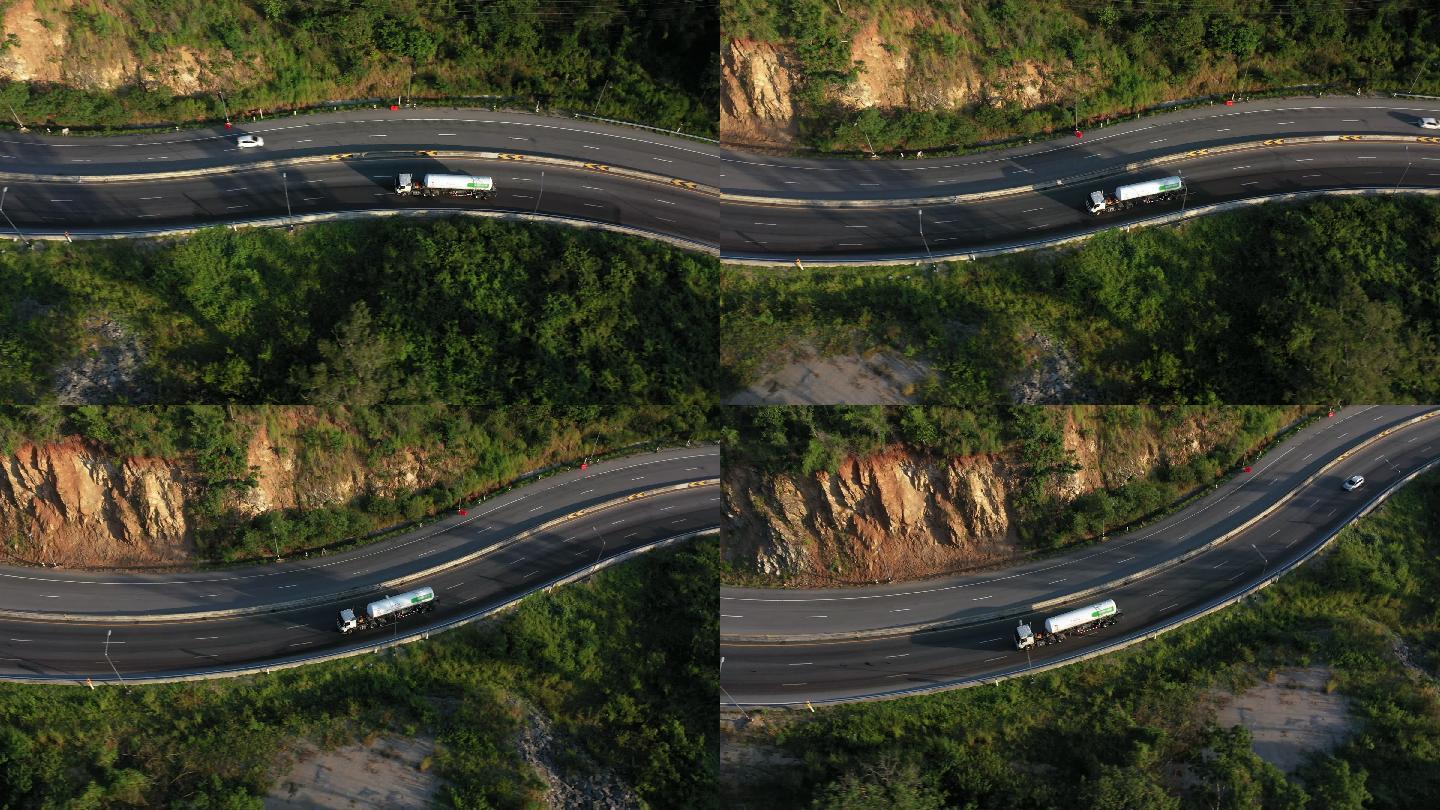 集装箱卡车在蜿蜒道路上行驶的跟踪拍摄