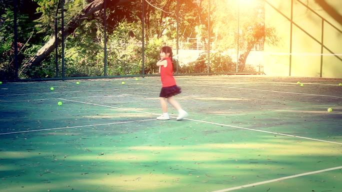 网球场上的小女孩打球接球高清素材