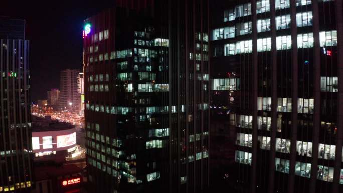 夜晚写字楼里加班人群-办公楼玻璃窗亮灯
