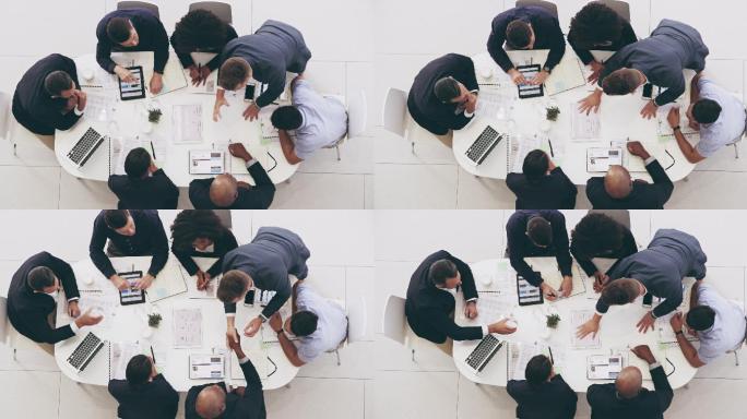 一群商人围着工作桌开会