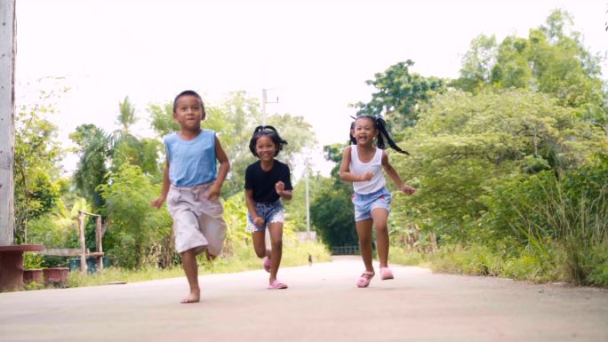 快乐的男孩和女孩快乐地奔跑，慢动作地笑。