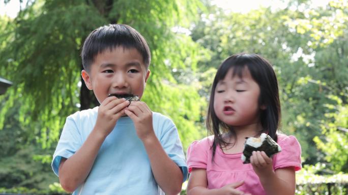 孩子在户外吃饭团日本小学生孩子日式美食